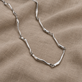 Collana in oro bianco con design a onda intrecciata